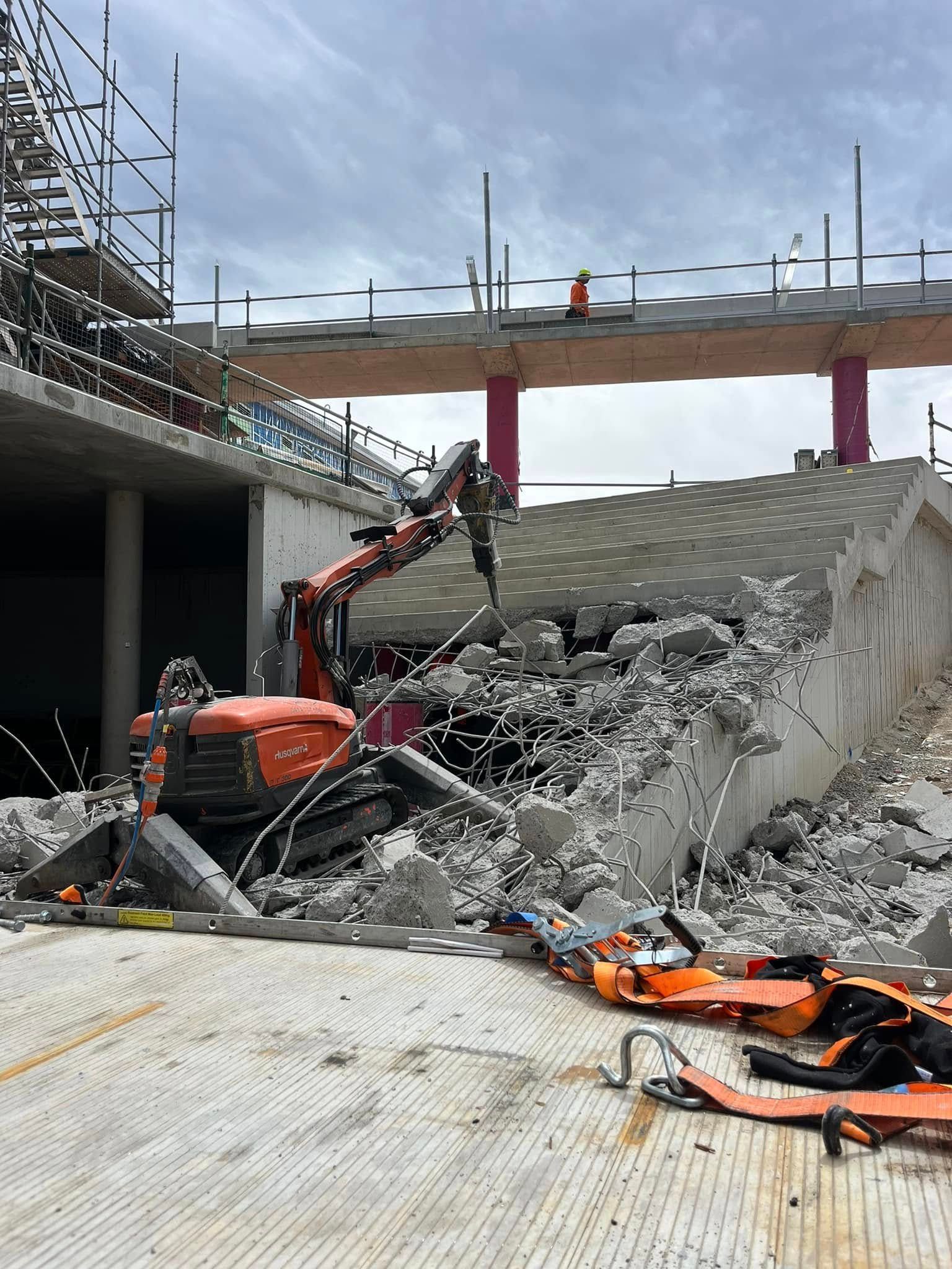 A large pile of concrete is being demolished by a bulldozer. — Newcastle Cut N Drill Pty Ltd In Boolaroo, NSW