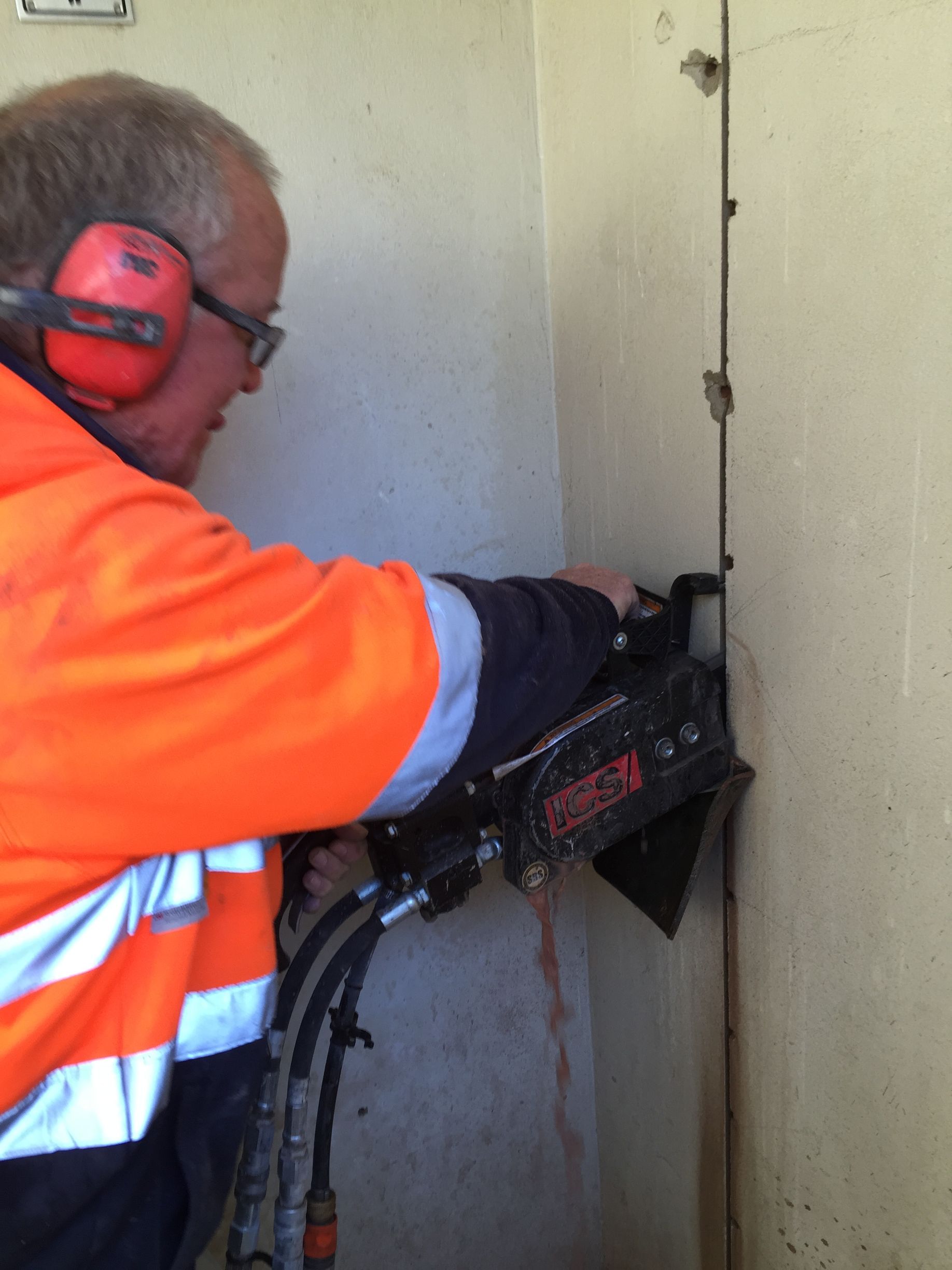 A man chain sawing into side of a building— Newcastle Cut N Drill Pty Ltd In Boolaroo, NSW