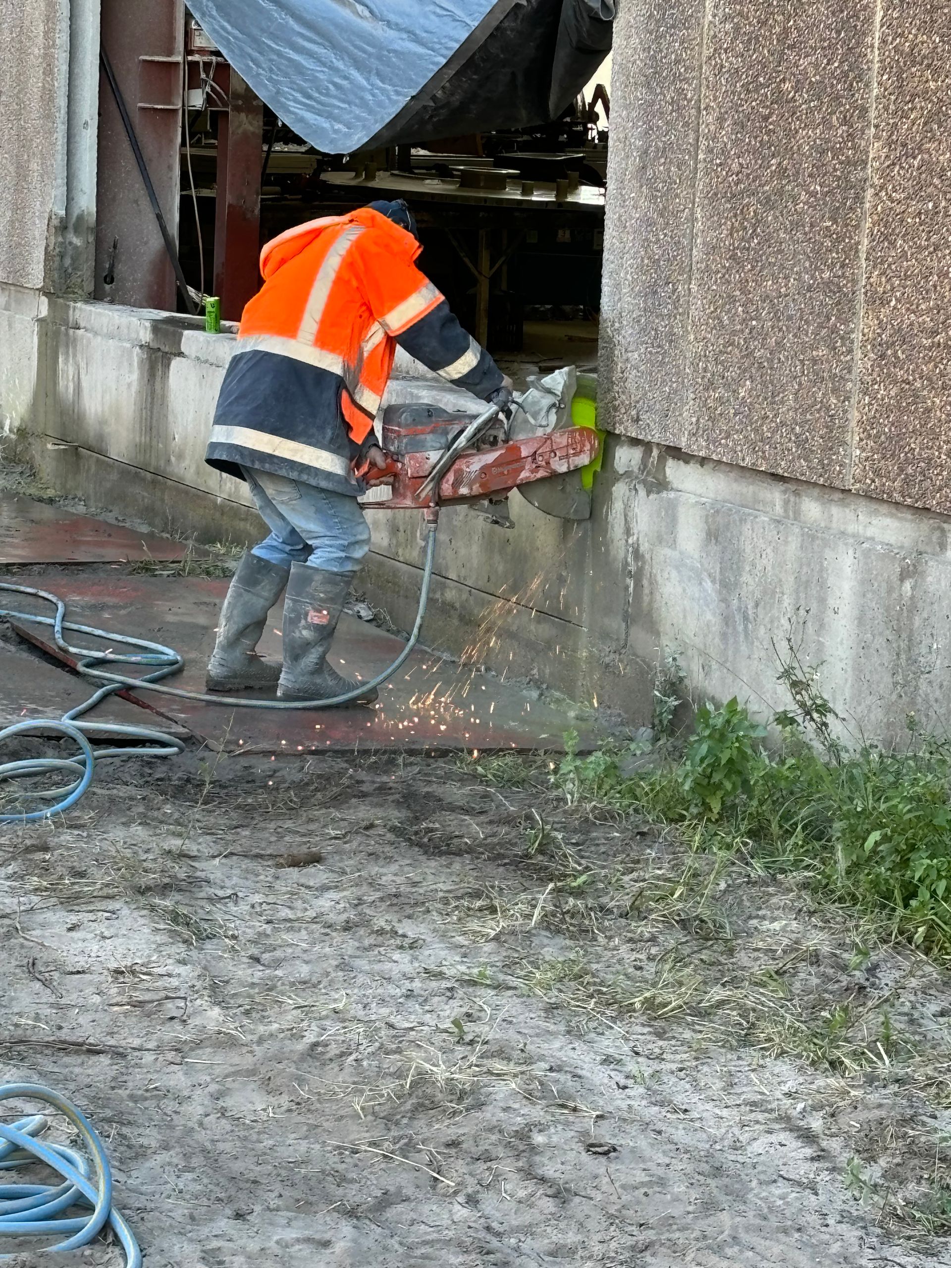 A man is using a circular saw to cut concrete. — Newcastle Cut N Drill Pty Ltd In Boolaroo, NSW