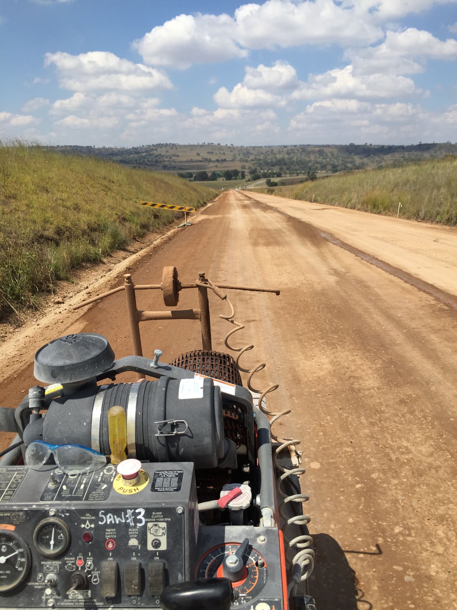 A machine is cutting concrete on a dirt road. — Newcastle Cut N Drill Pty Ltd In Boolaroo, NSW