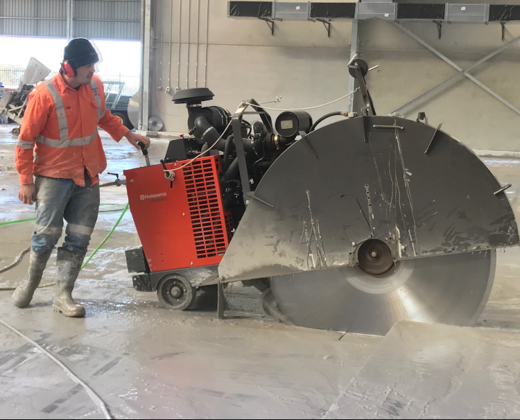 A person is using a concrete saw to cut concrete. — Newcastle Cut N Drill Pty Ltd In Boolaroo, NSW