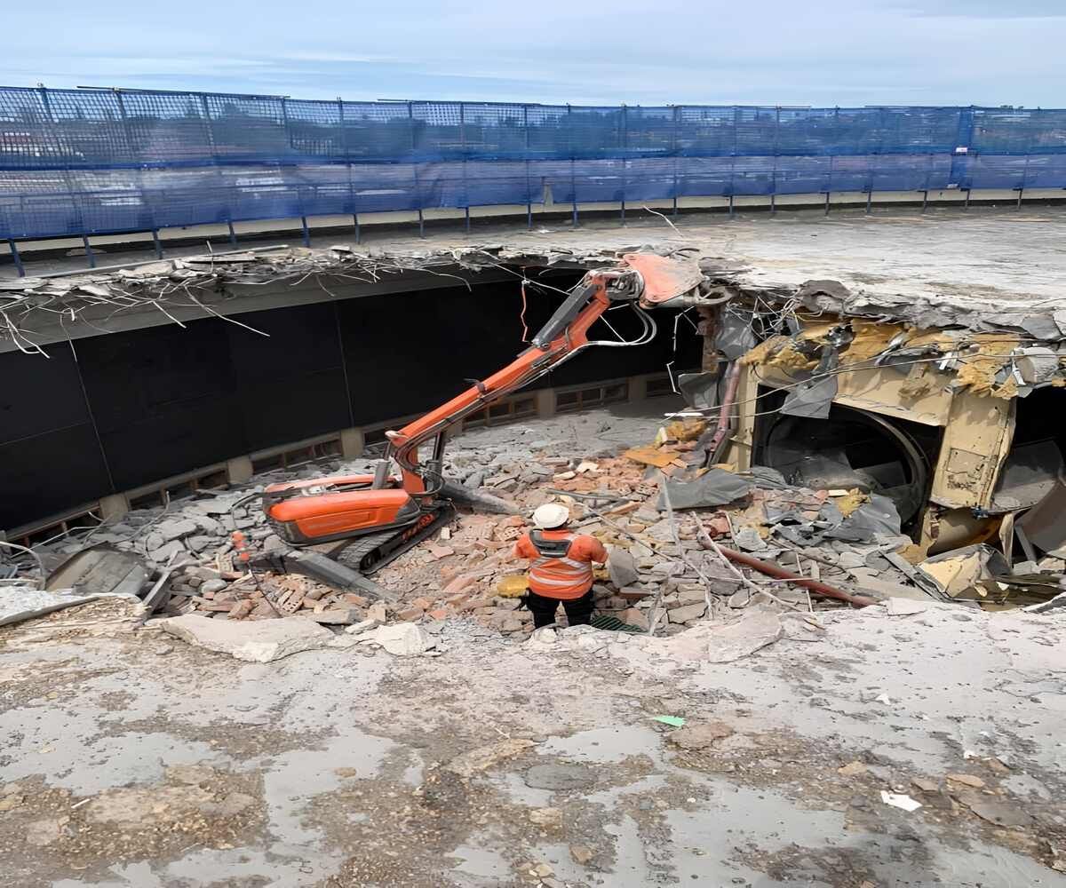 A Construction Worker Is Standing In The Middle Of A Demolition Site — Newcastle Cut N Drill Pty Ltd In Boolaroo, NSW