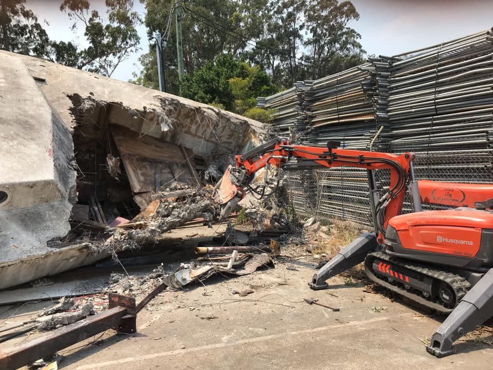 A Large Concrete Structure Is Being Demolished By A Robotic Excavator — Newcastle Cut N Drill Pty Ltd In Boolaroo, NSW