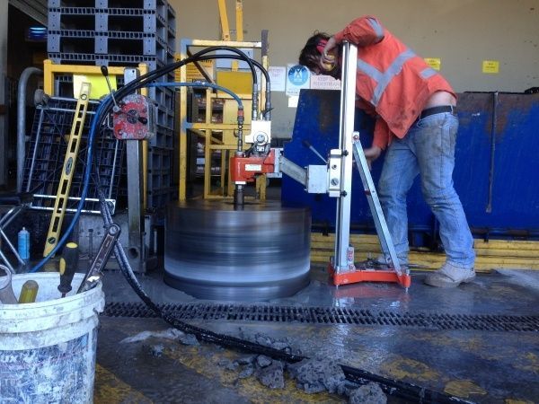 A Man Is Using A Machine To Cut A Hole In The Ground — Newcastle Cut N Drill Pty Ltd In Boolaroo, NSW