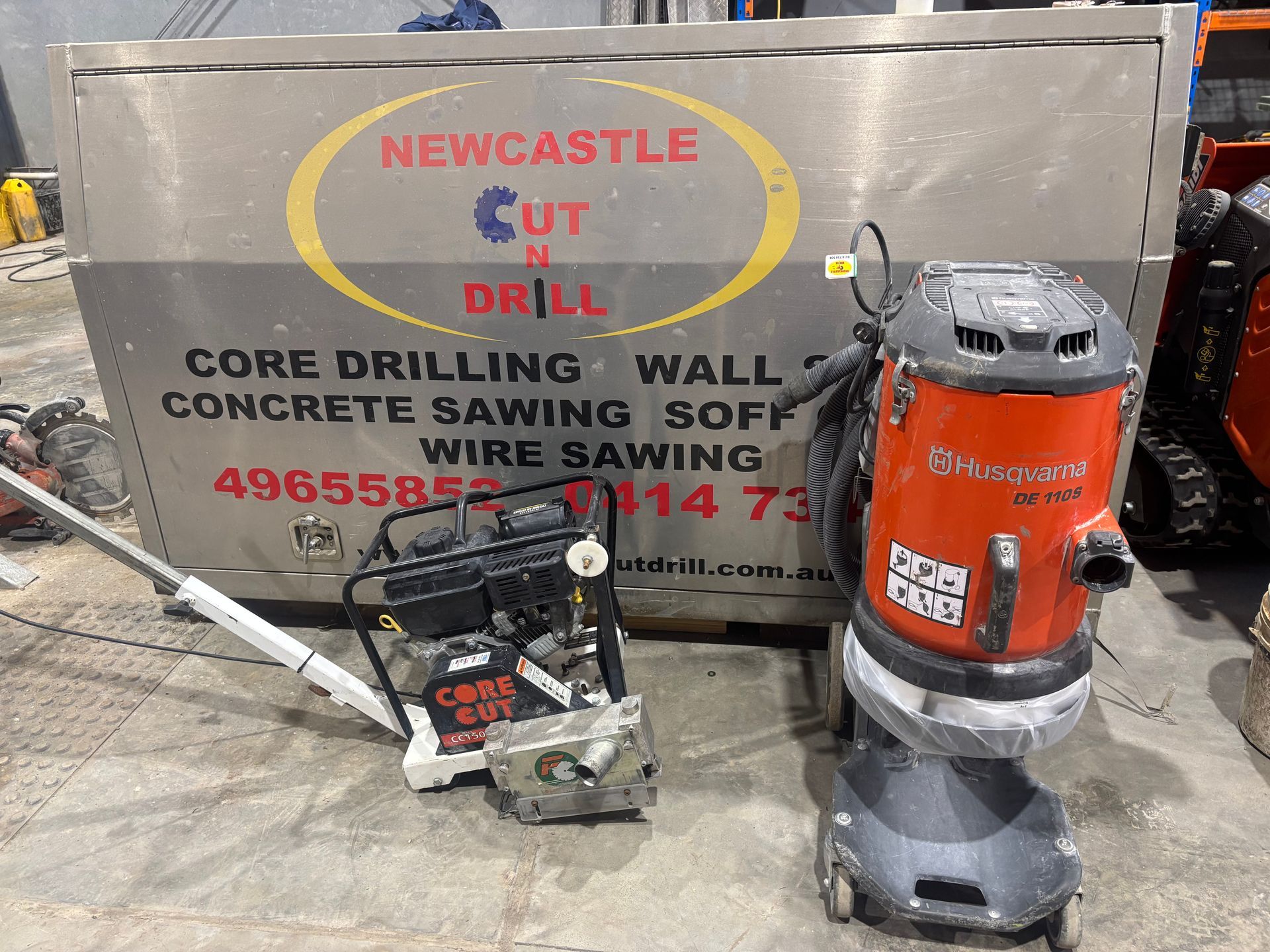 Small concrete cutters in front of a sign — Newcastle Cut N Drill Pty Ltd In Boolaroo, NSW