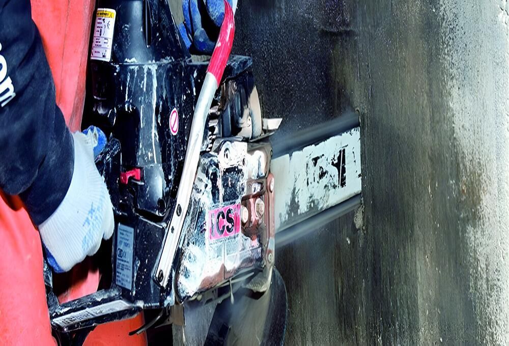 A Person Is Using A Chainsaw To Cut A Hole In A Wall — Newcastle Cut N Drill Pty Ltd In Boolaroo, NSW