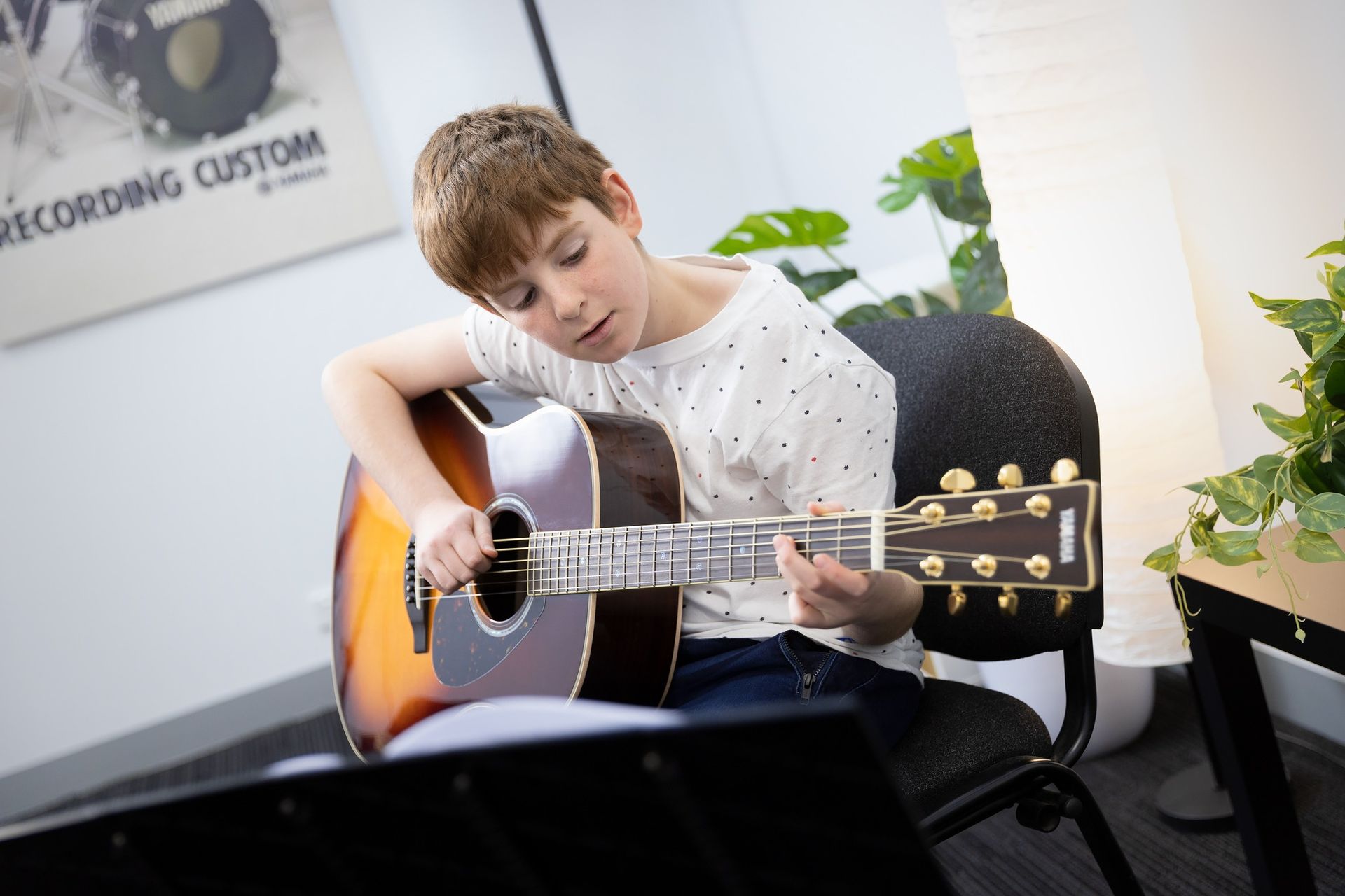 Guitar teacher adjusting student’s hold during lesson
