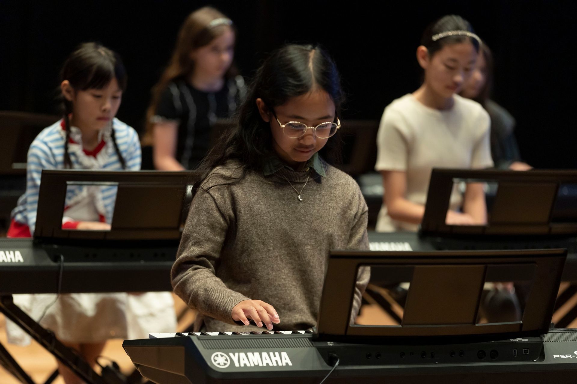 Child taking piano lessons with music teacher in Edmonton