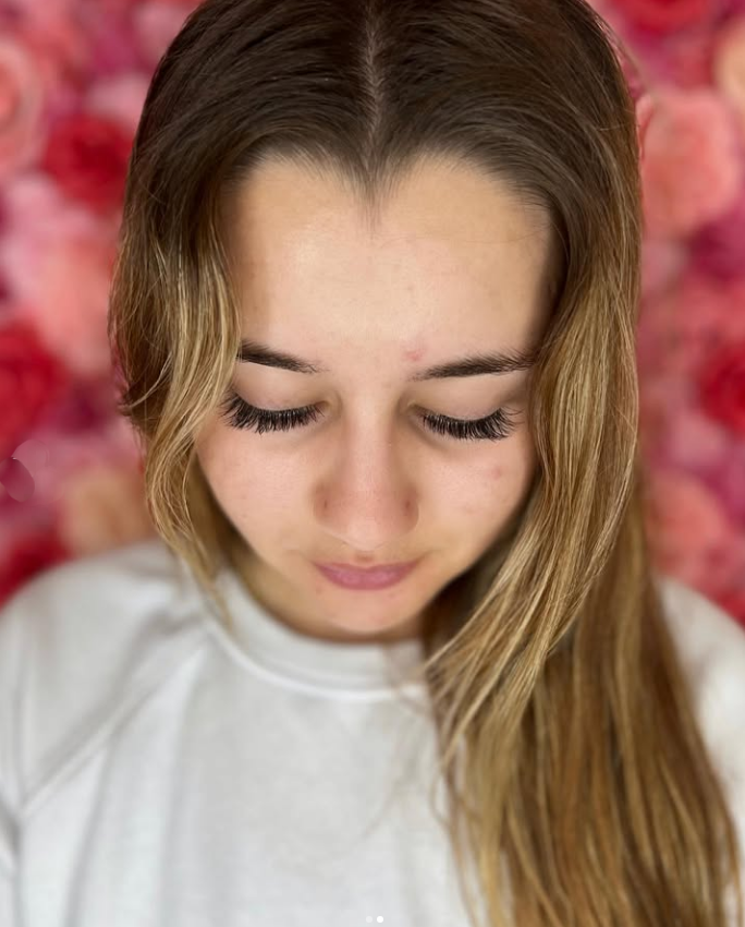 A close up of a woman 's face with her eyes closed.