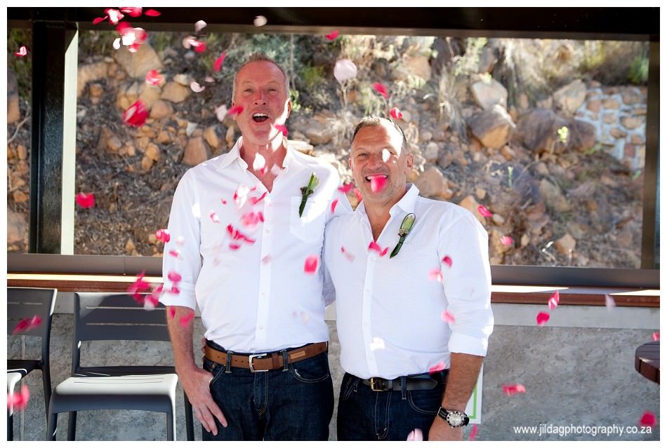 Two men are posing for a picture with confetti falling around them.
