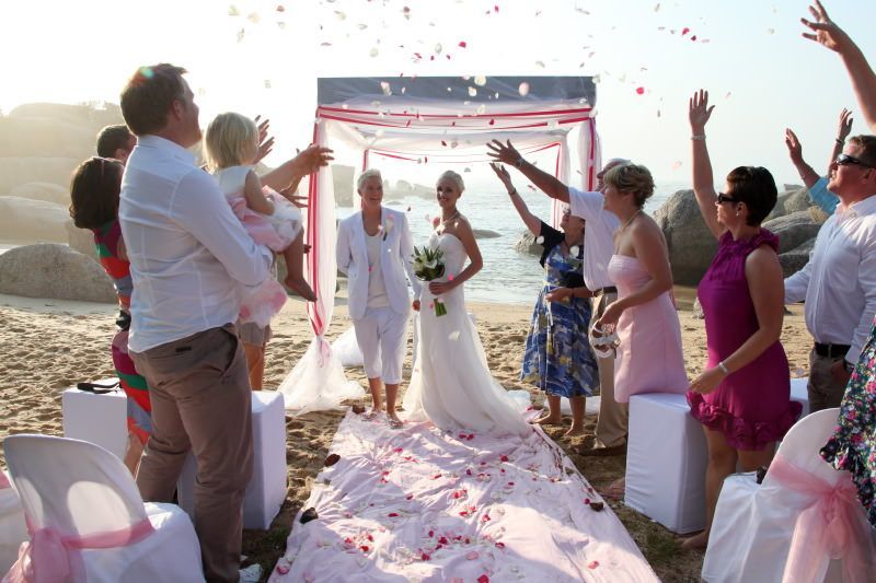A bride and groom are celebrating their wedding on the beach