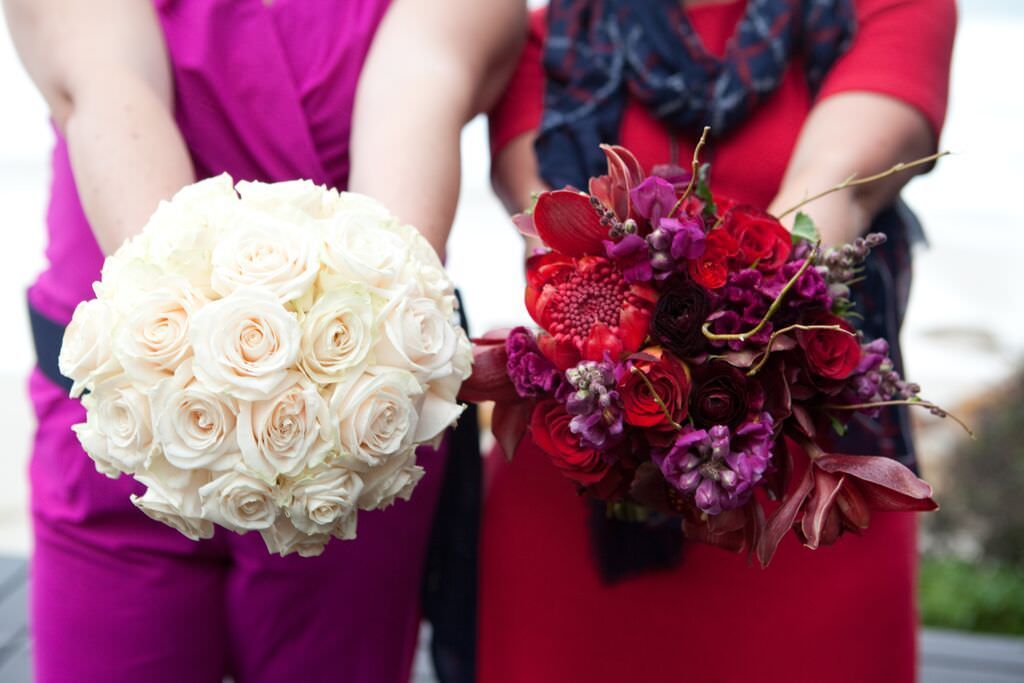 Two women are holding bouquets of flowers in their hands.