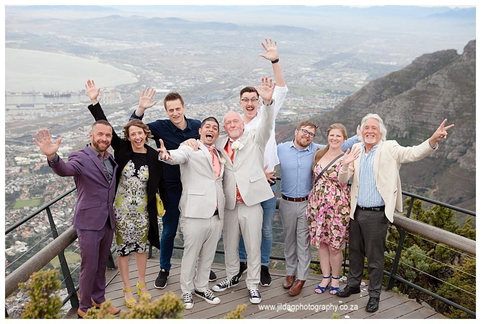 A group of people are posing for a picture on top of a mountain.