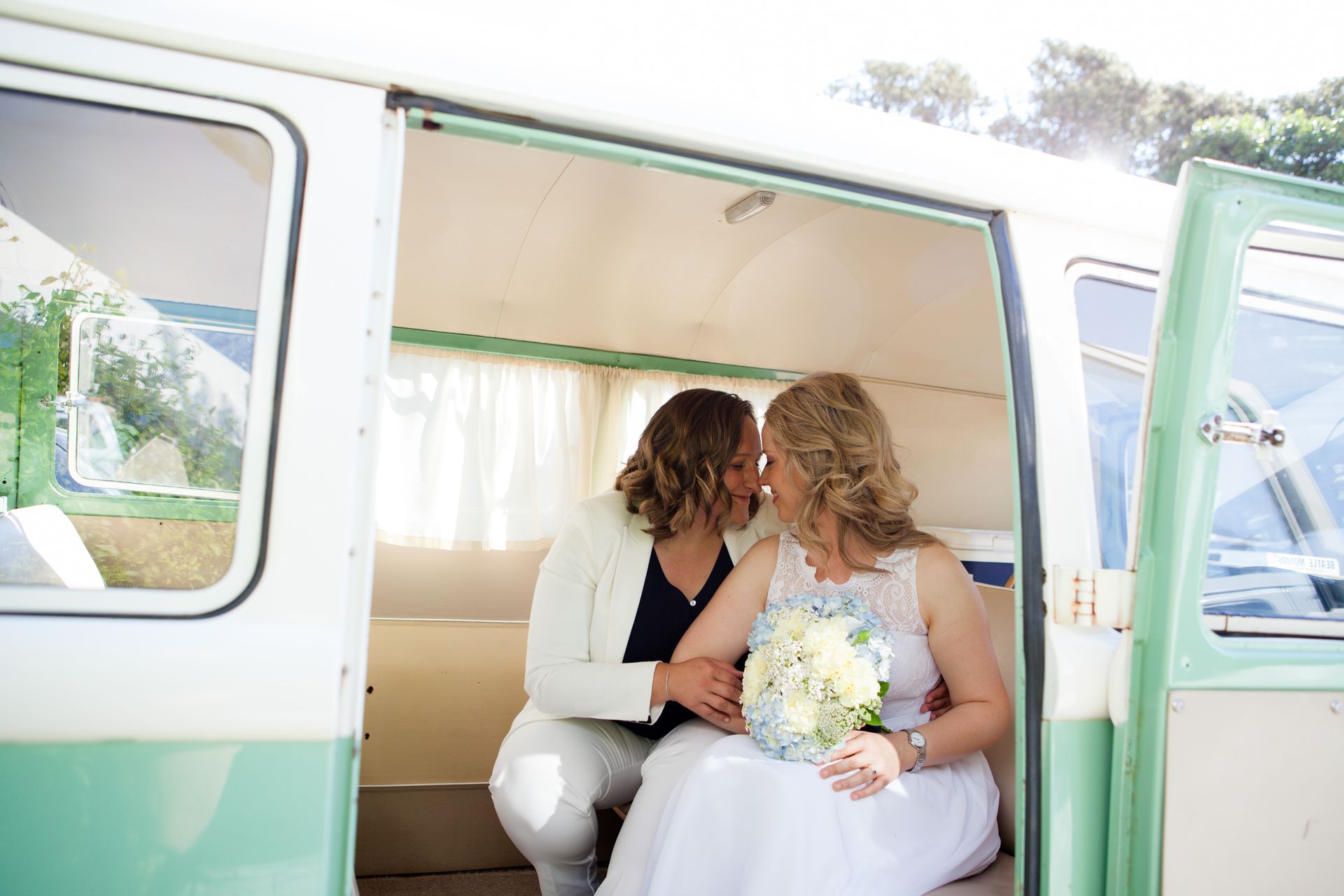 Two women are kissing in the back of a van.