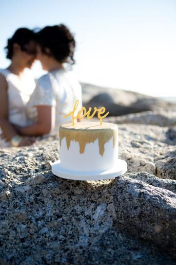 A cake with the word love on it is sitting on a rock.