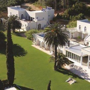 A bride and groom kissing in front of the ocean