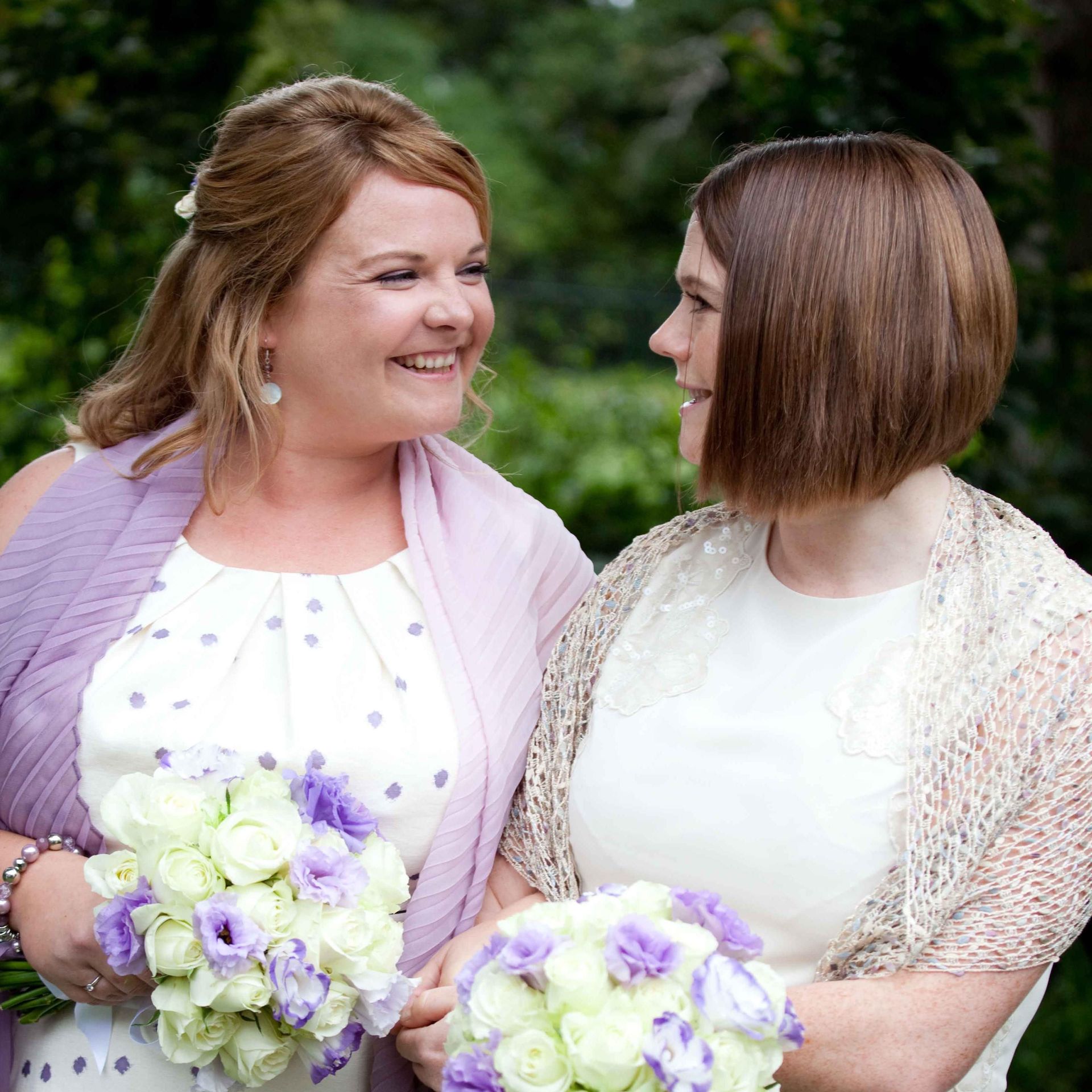 A bride and groom are posing for a picture at their wedding . the bride is wearing a flower crown.