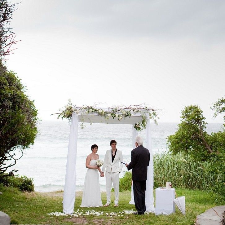 A bride and groom are hugging each other and smiling for the camera.