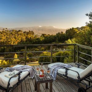 A bride and groom are standing on a balcony overlooking a city.