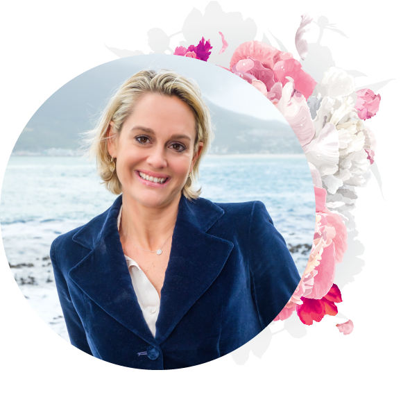 A woman in a blue jacket is surrounded by pink flowers