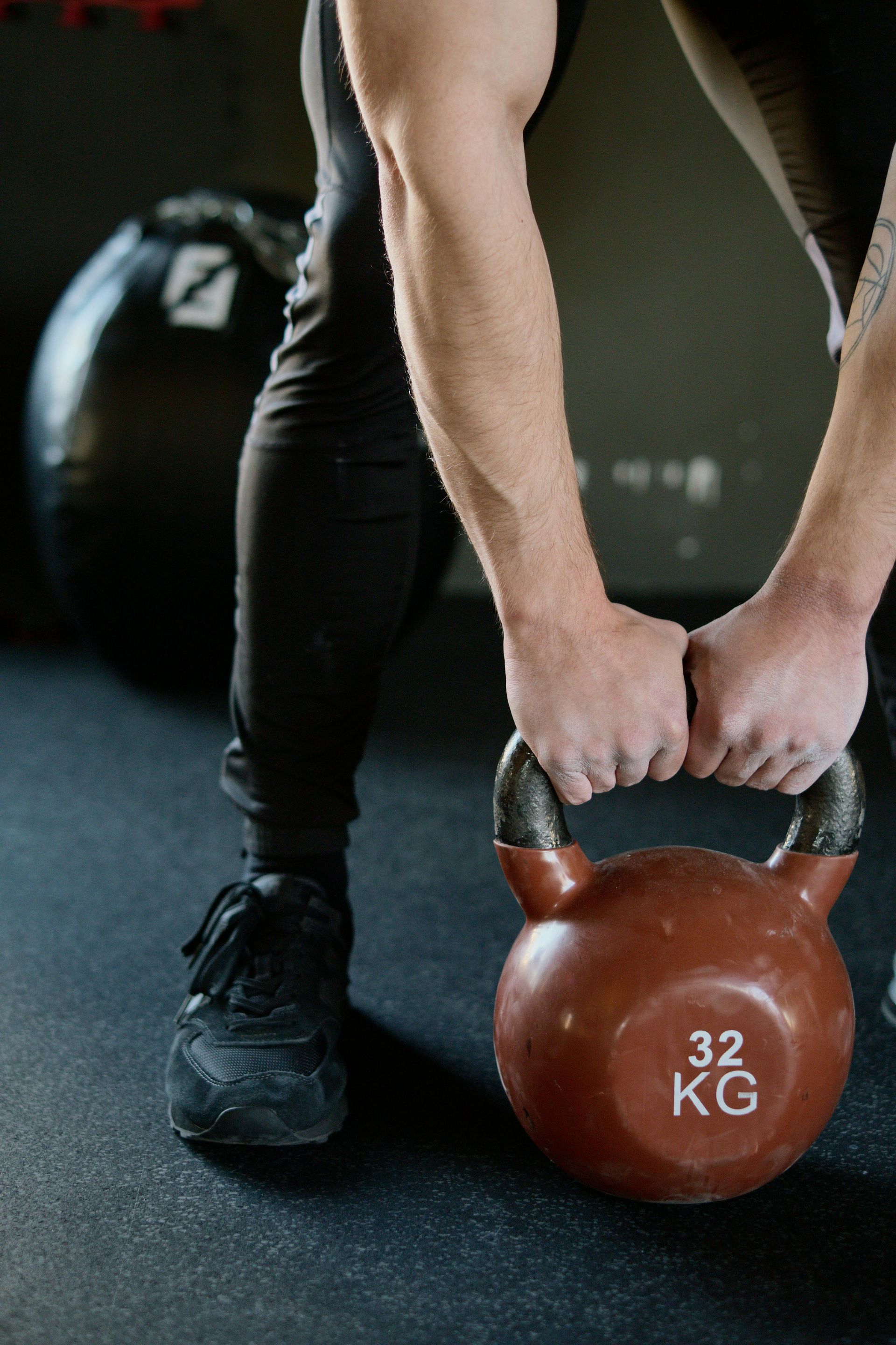 Een man tilt een kettlebell op in een sportschool.