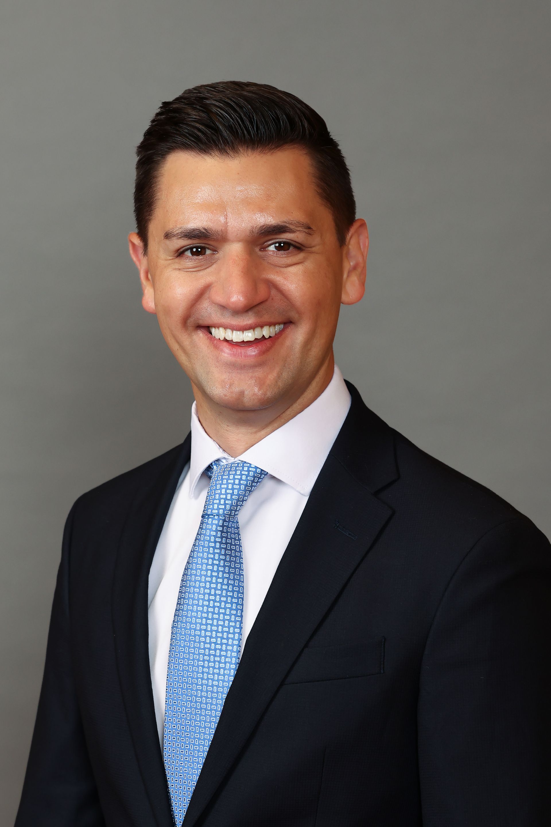 A man in a suit and tie is smiling for the camera.