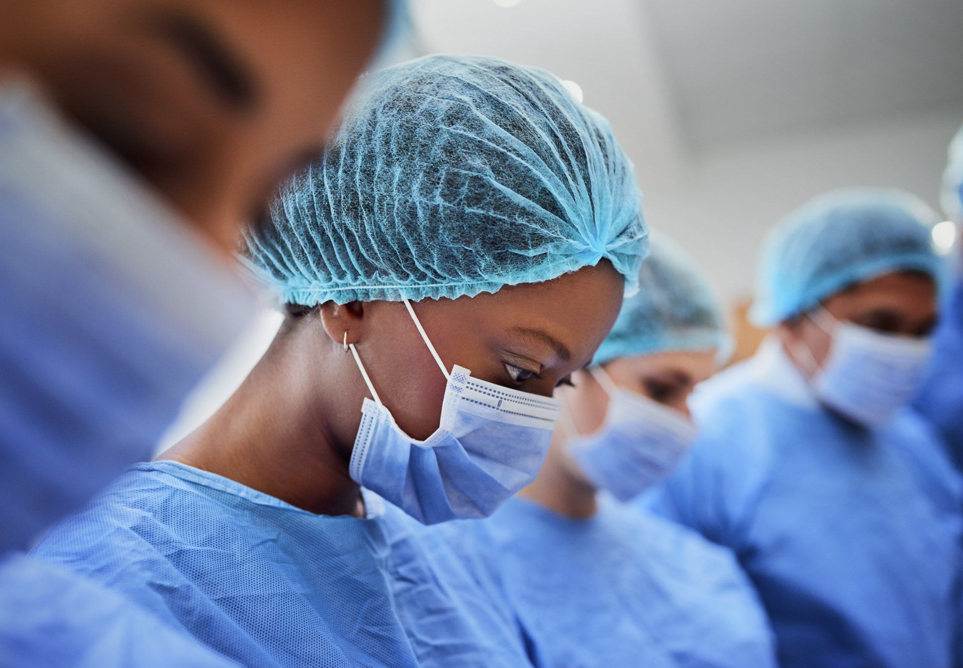 A group of surgeons wearing surgical gowns and masks in an operating room.