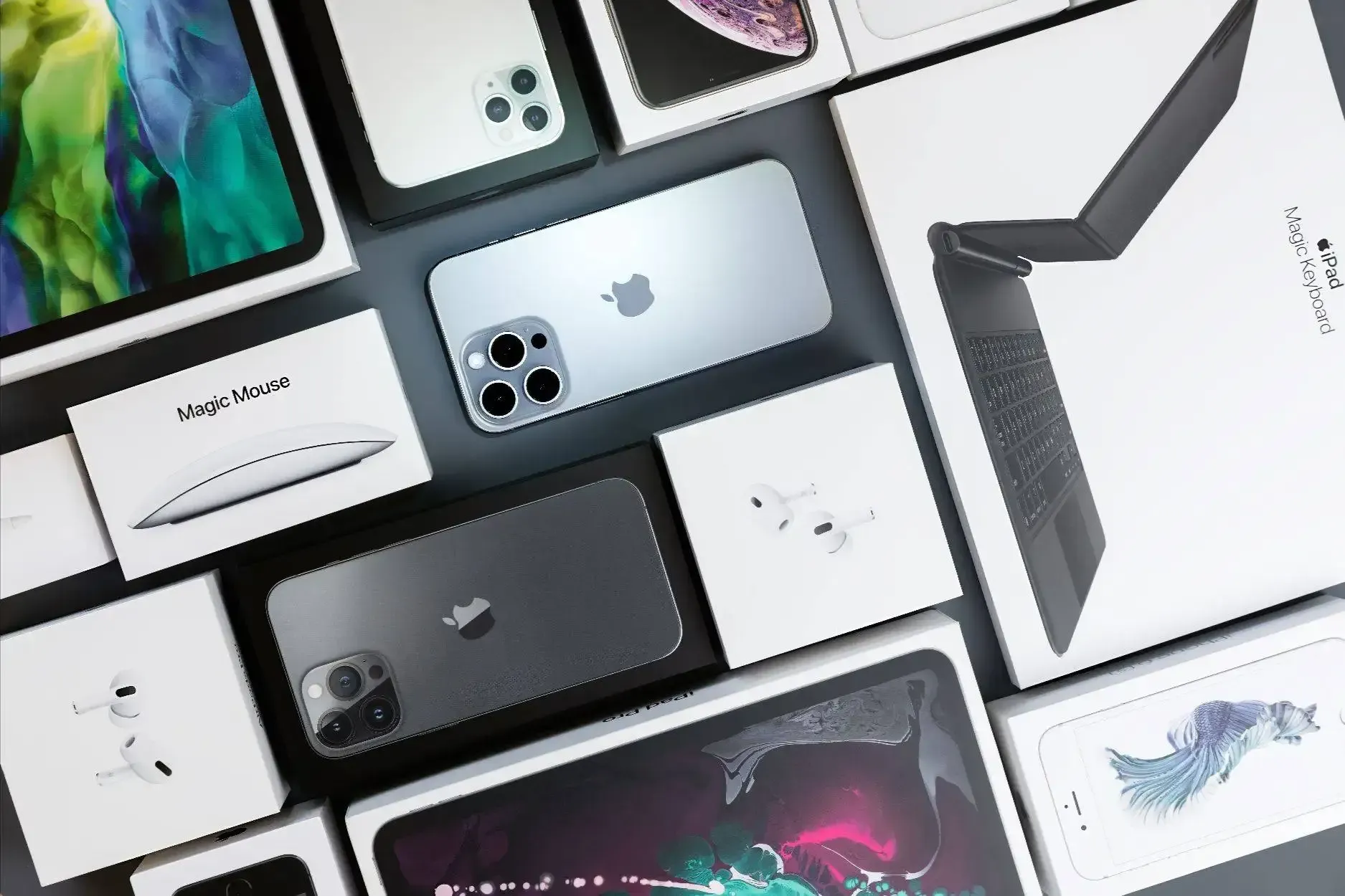 Assorted Apple devices and boxes arranged in a flat lay on a white surface.