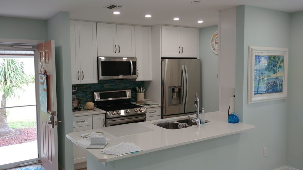 A kitchen with stainless steel appliances and white cabinets.