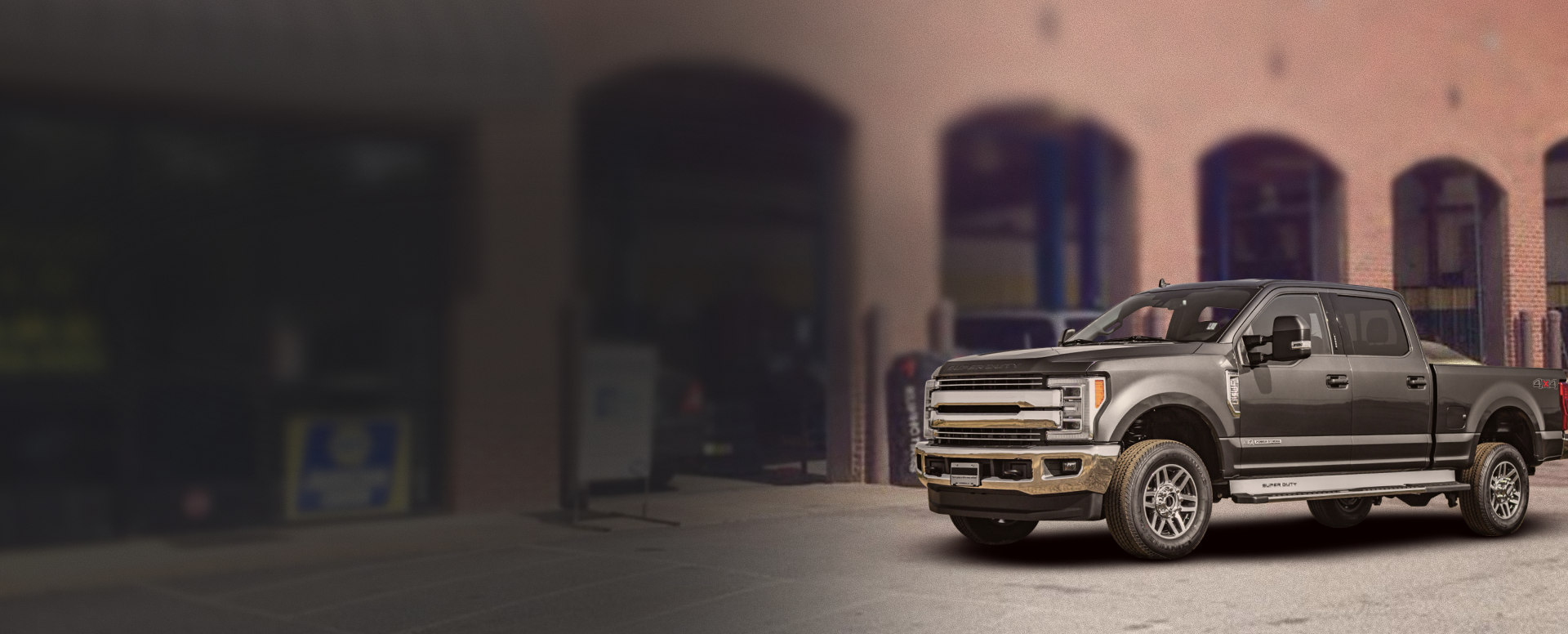 Dark gray pickup truck parked in front of a brick building. | Top Quality Car Care