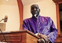 Bishop John Smith, Jr. in a purple suite standing at a podium Georgetown, SC The Greater Bibleway Church of Georgetown