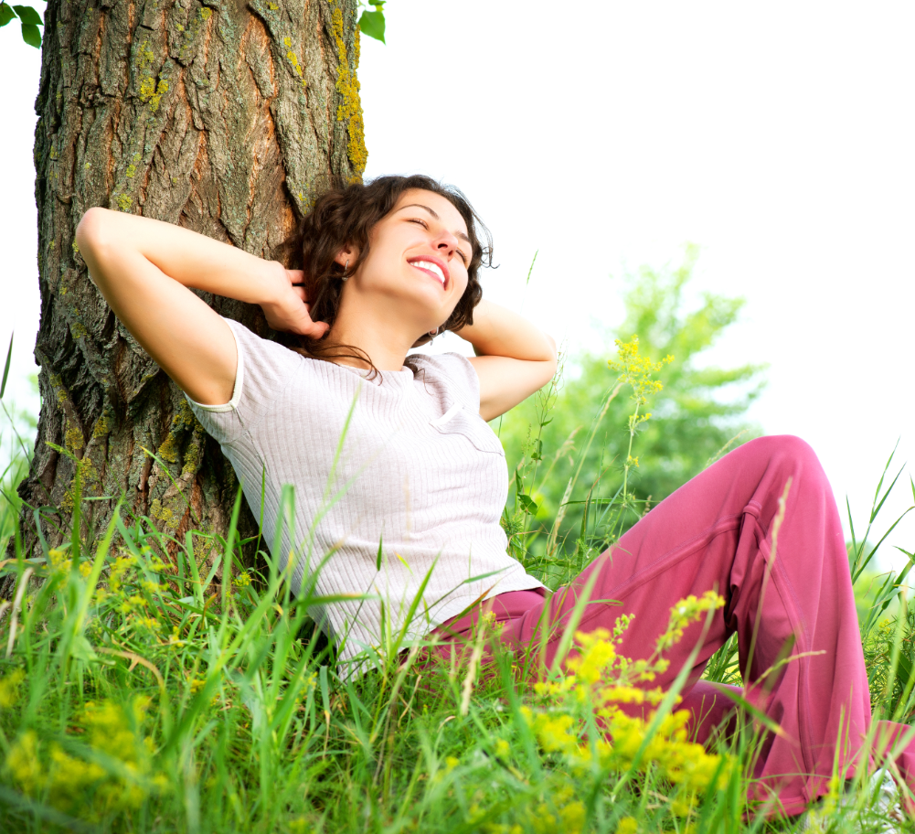 Lady relaxing against a tree