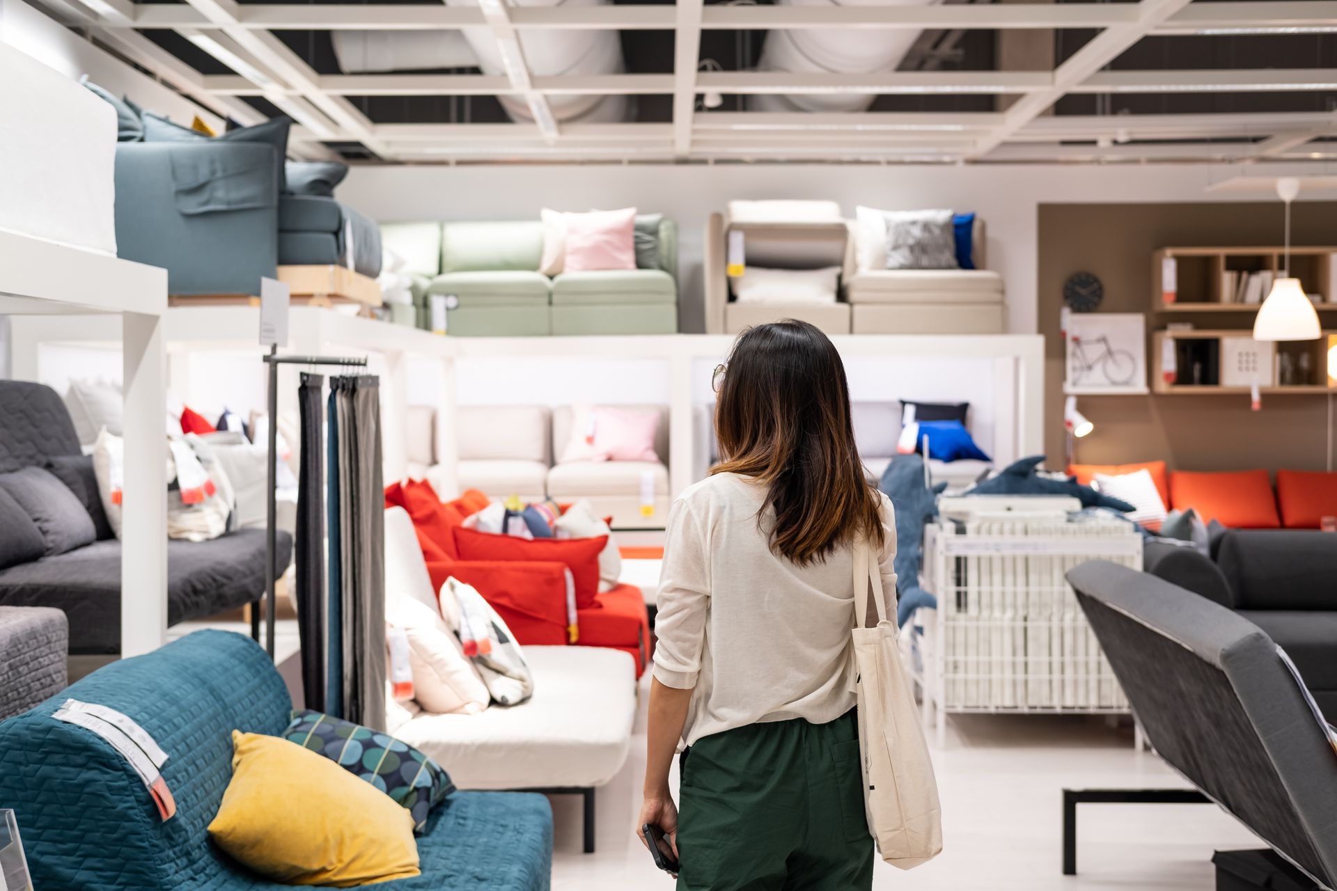 A woman is walking at a furniture store.