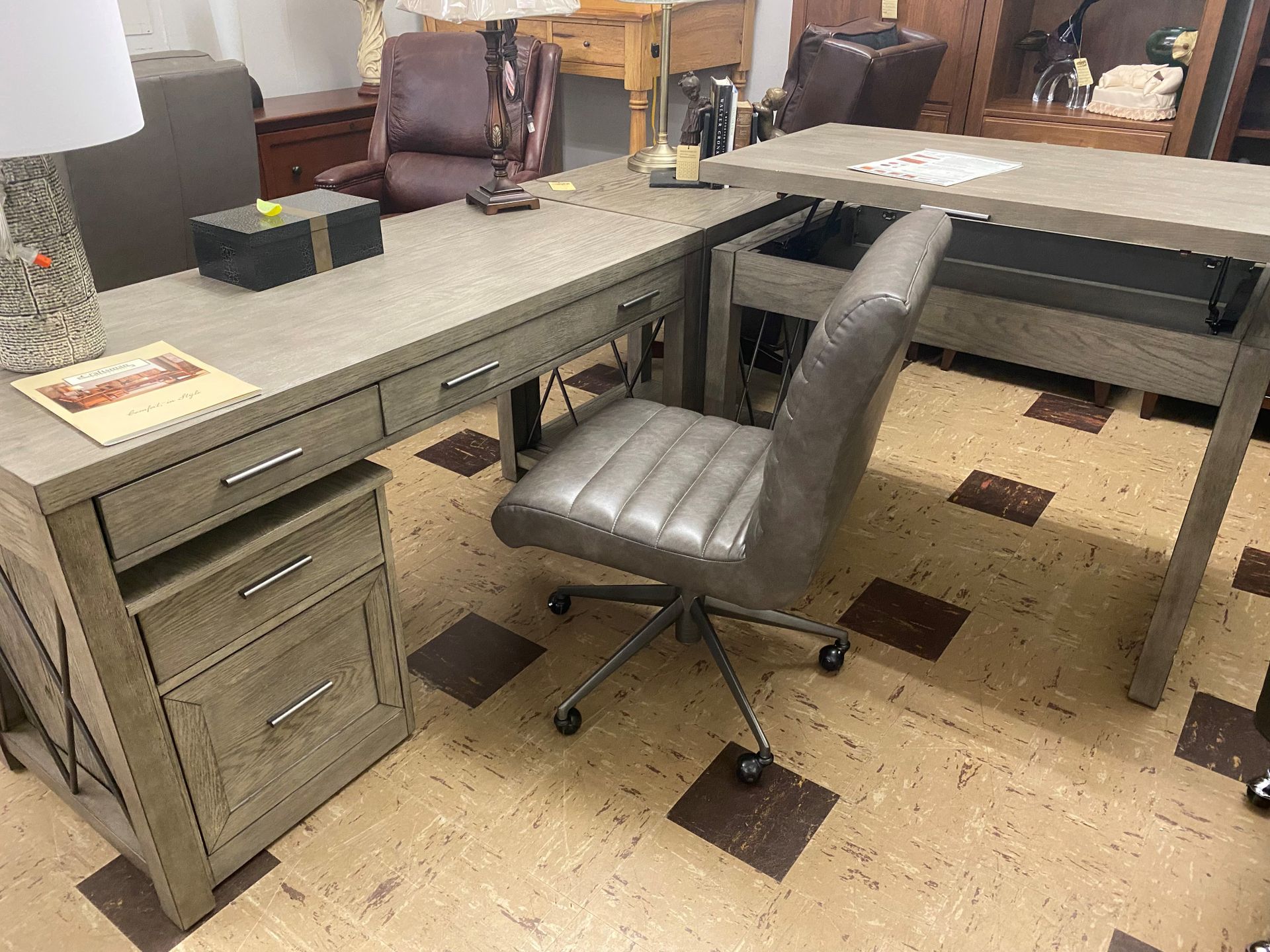 A gray L-shaped desk with a matching chair, and a beige floor.