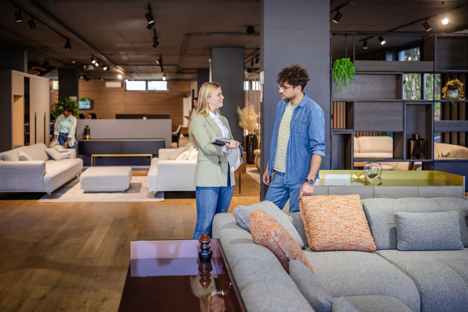 Man and woman discuss fabric samples in showroom. Man and woman discuss fabric samples in showroom.