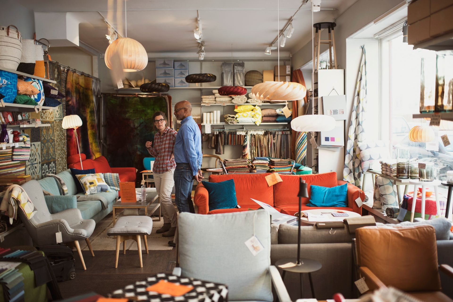 Owner showing furniture to customer at store.