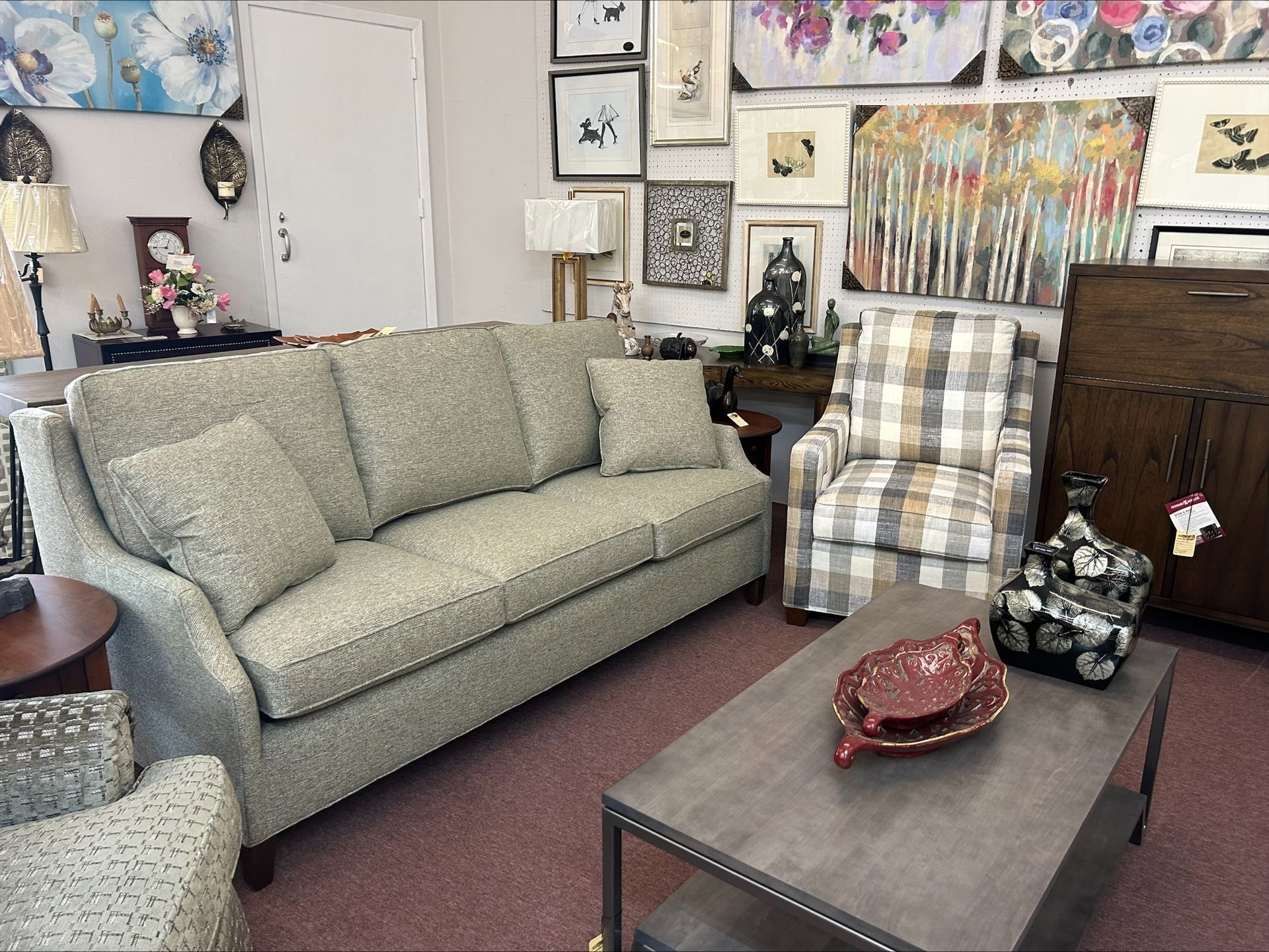Living room set: patterned sofa, plaid chair, metal coffee table with decor, and wall art.