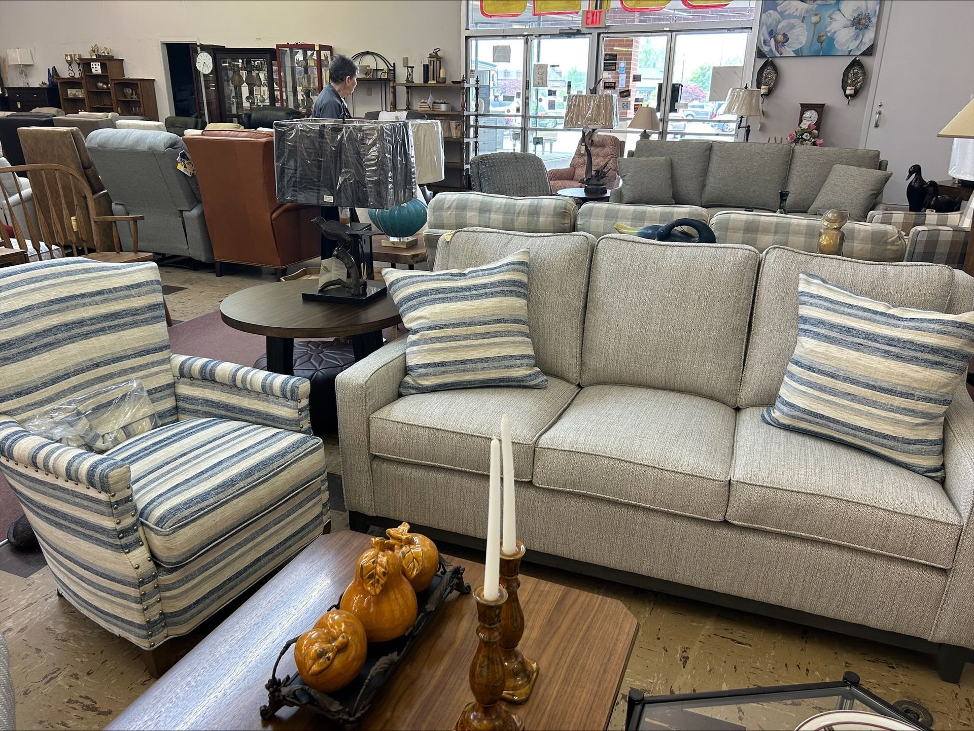 Interior of a furniture store featuring a sofa, chair, and various home decor items on display.