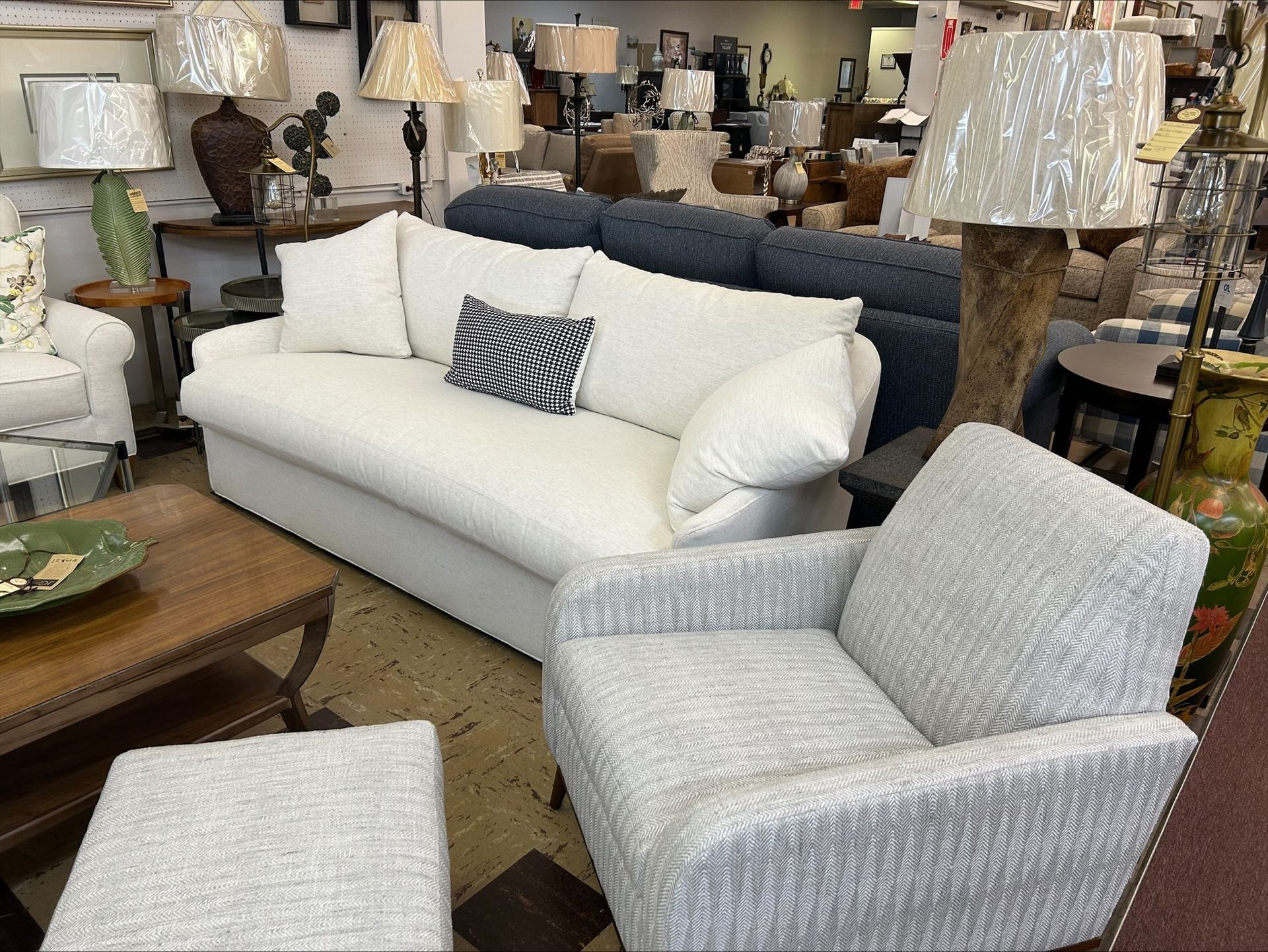 White sofa, blue sofa, and patterned chair in a furniture store.