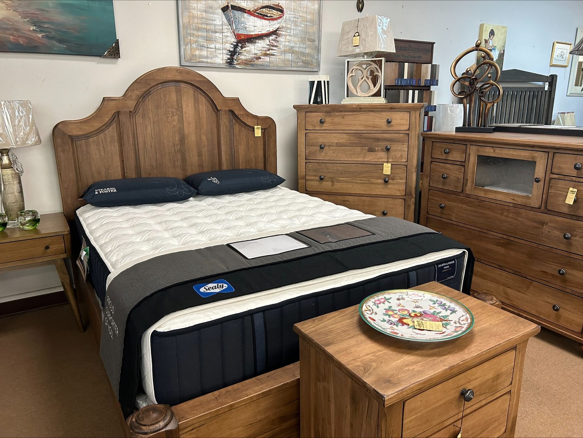 Bedroom set with wooden bed, mattress, nightstand, and dressers.