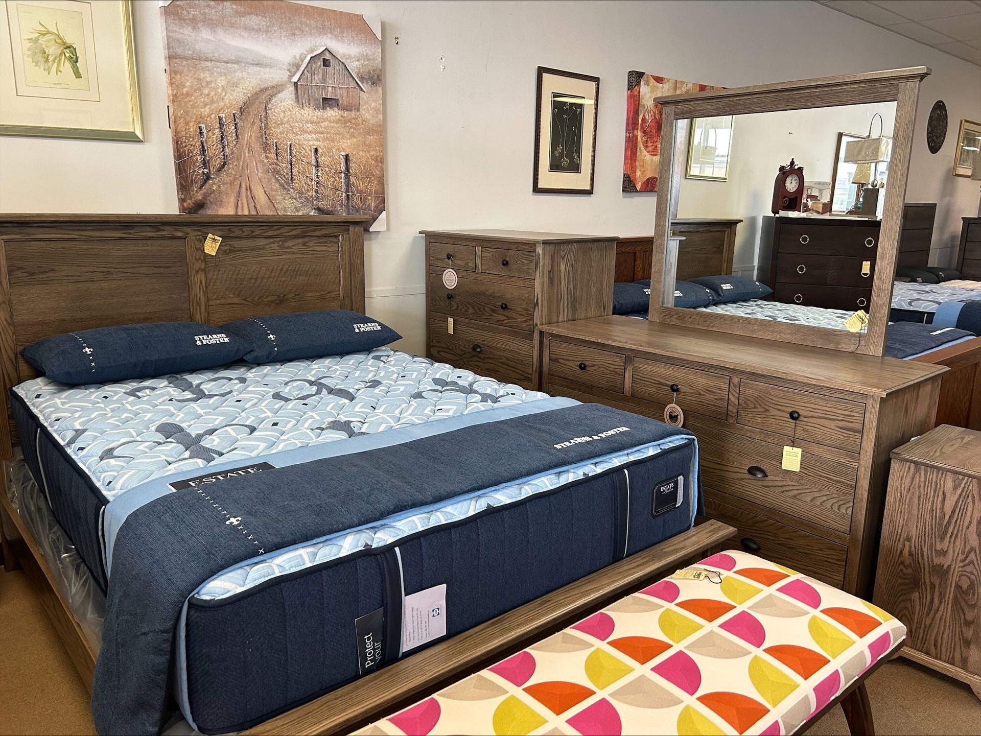 Bedroom set with a bed, dresser, mirror, and bench.