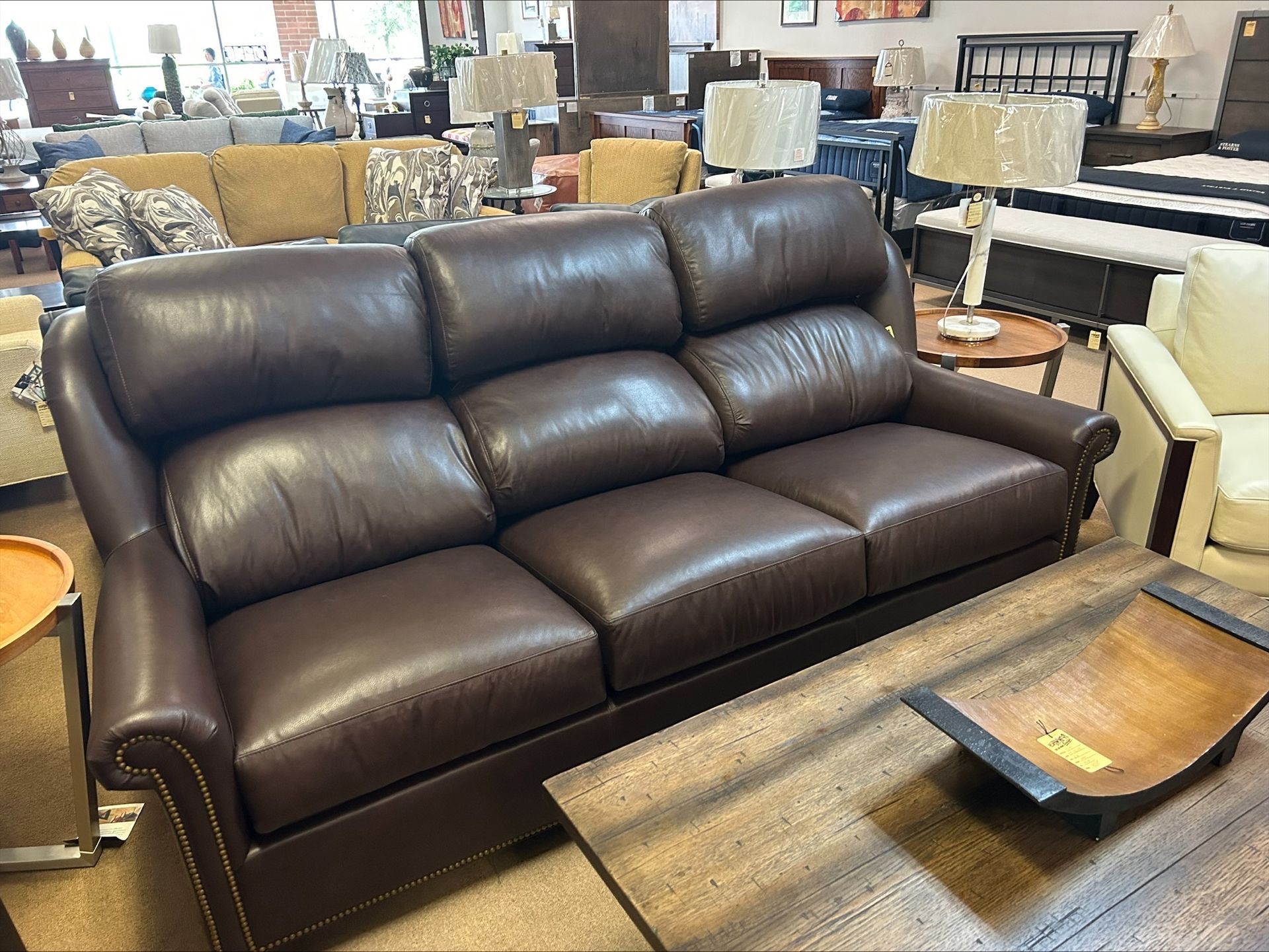 Brown leather sofa in a furniture store setting.