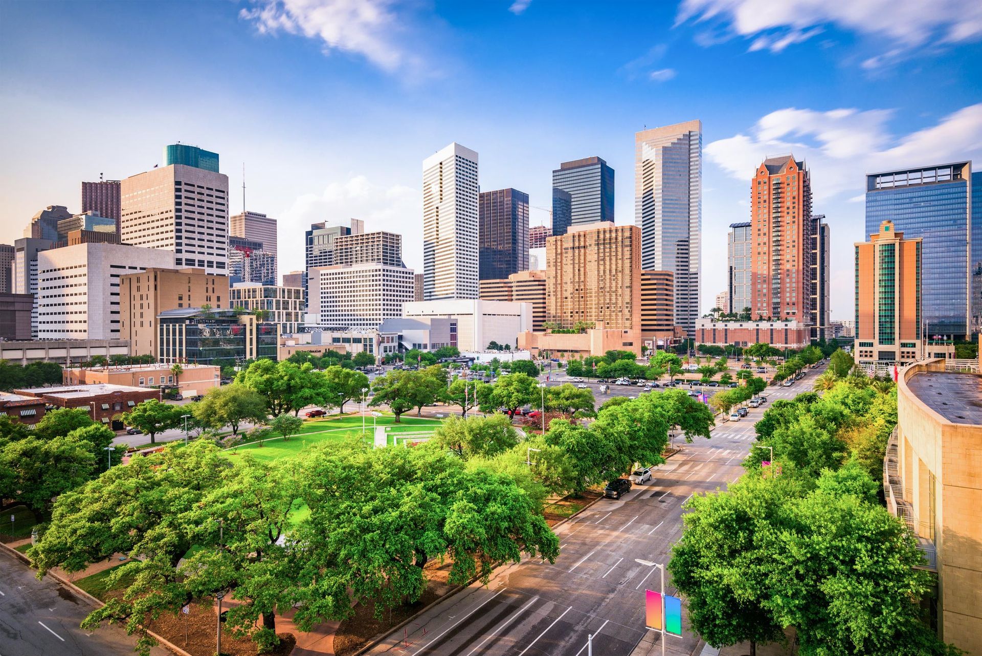 An aerial view of a city skyline with a park in the foreground.