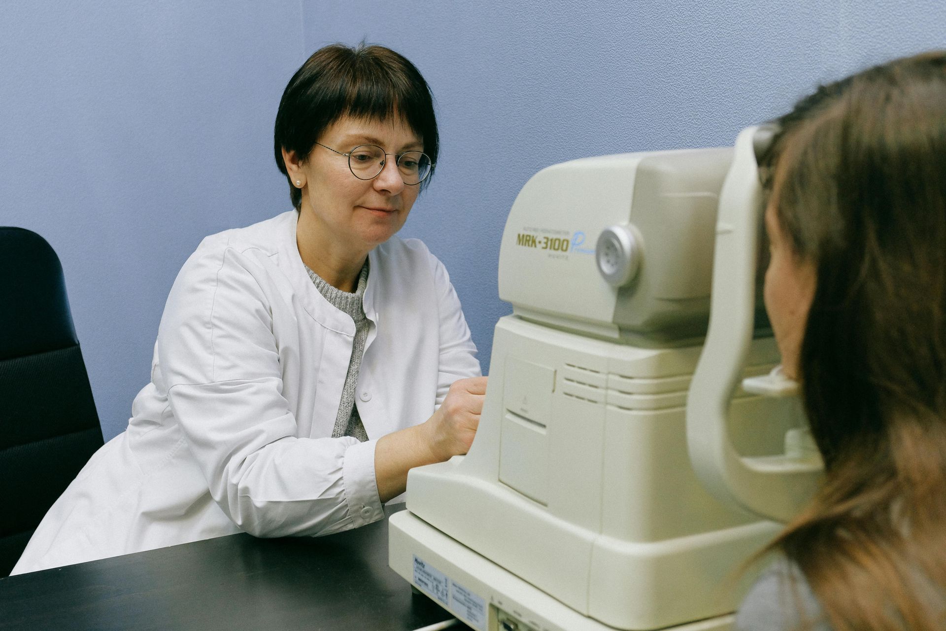A woman is getting her eyes checked by an ophthalmologist.
