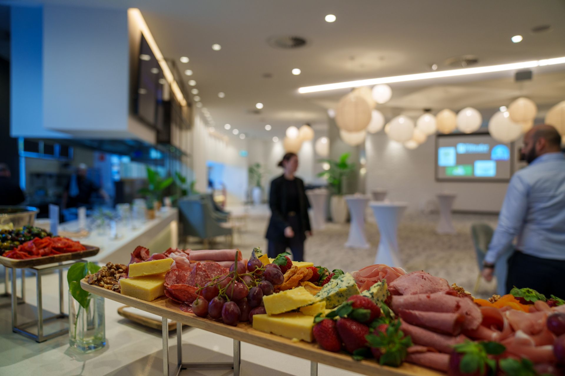 Modern function room set up with cocktail tables and hanging lanterns