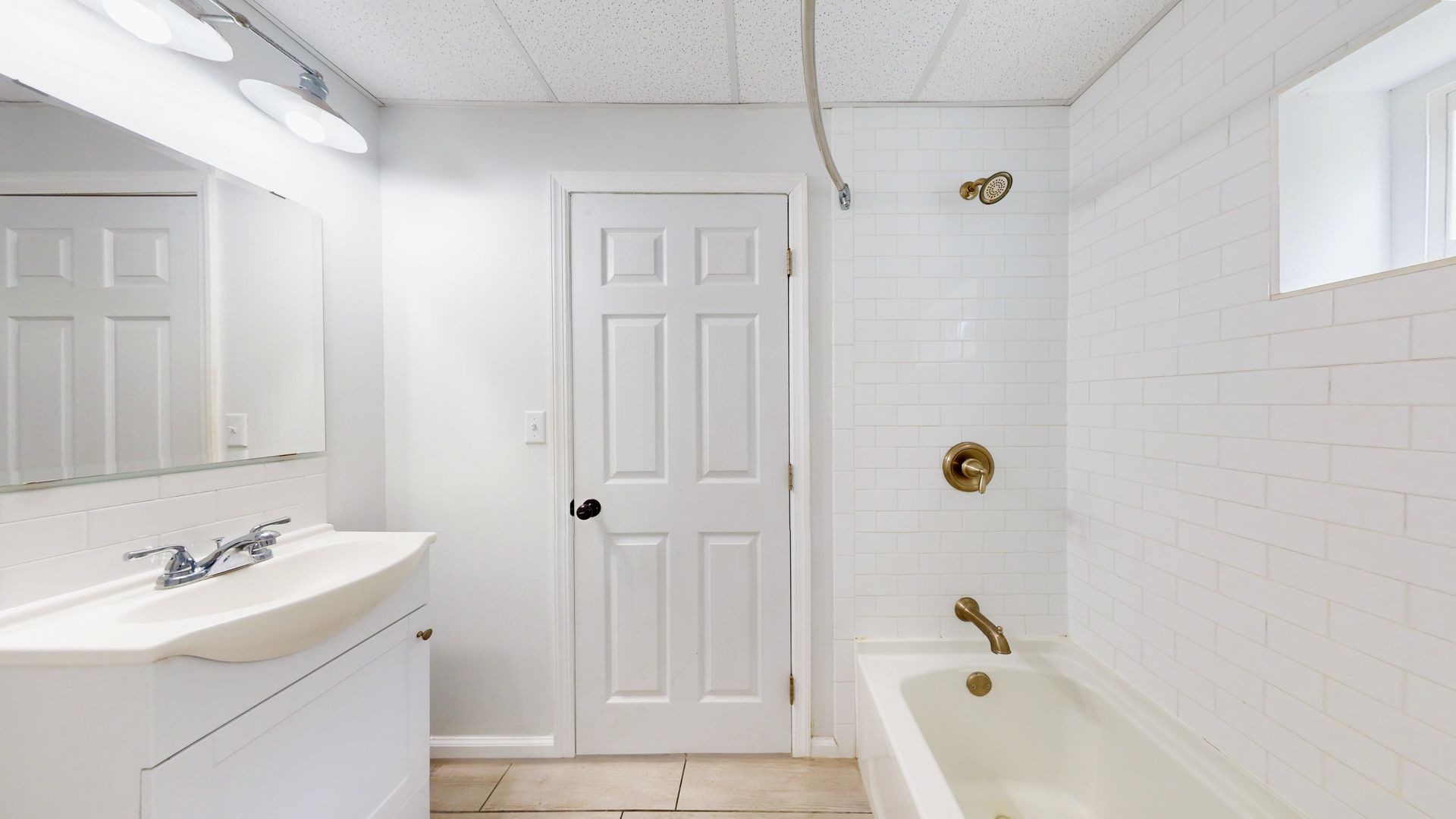 A bathroom with a sink , tub , shower and mirror.