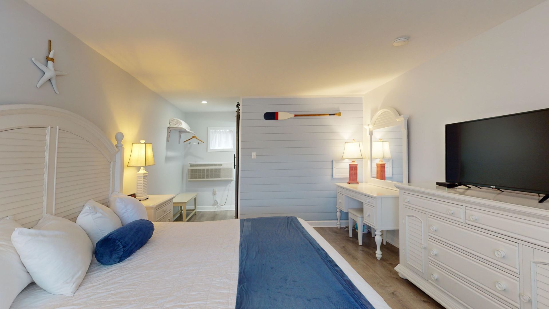 A hotel room with a king size bed and a flat screen tv.