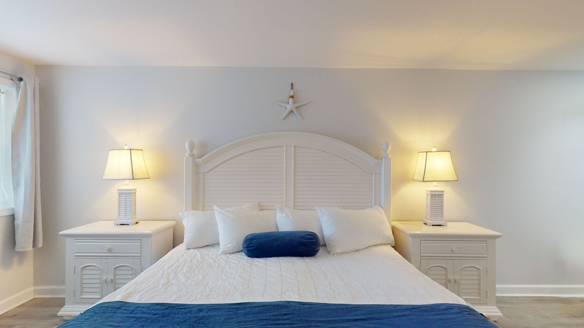 A bedroom with a king size bed and two nightstands.