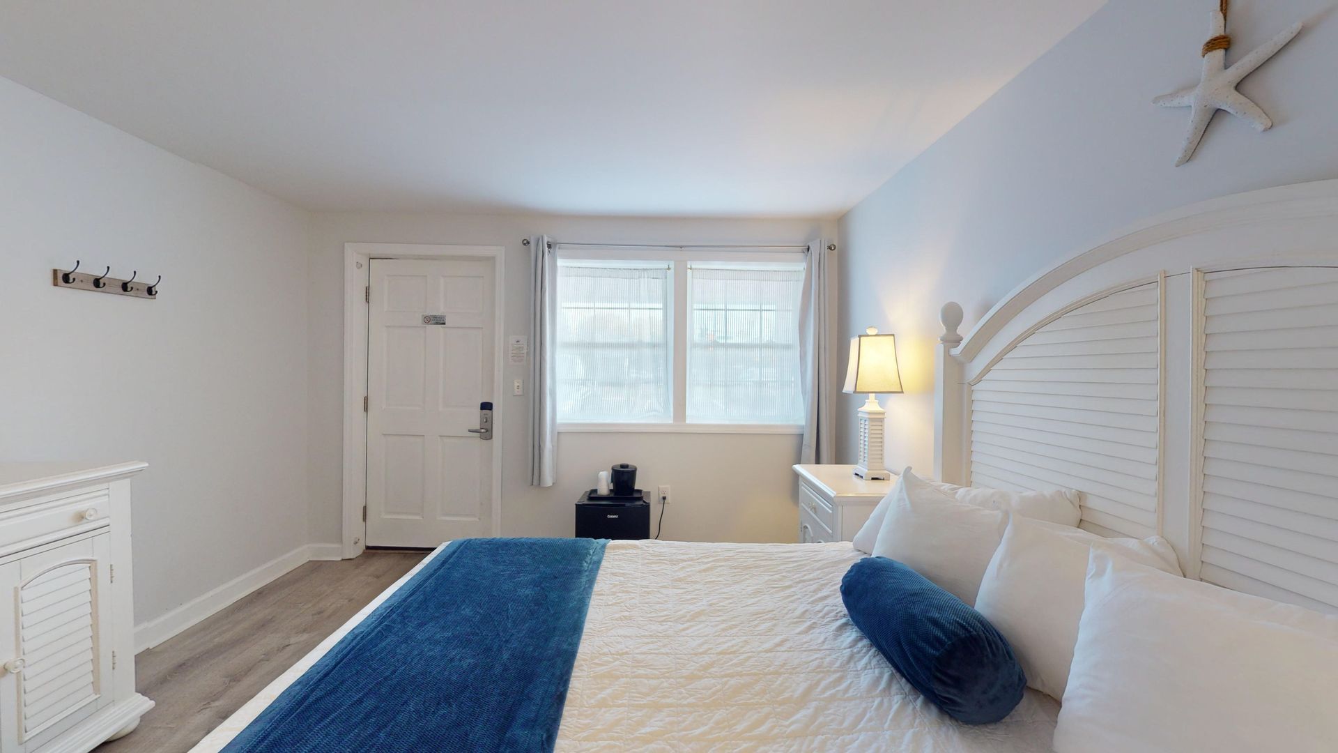 A bedroom with a king size bed and a dresser.