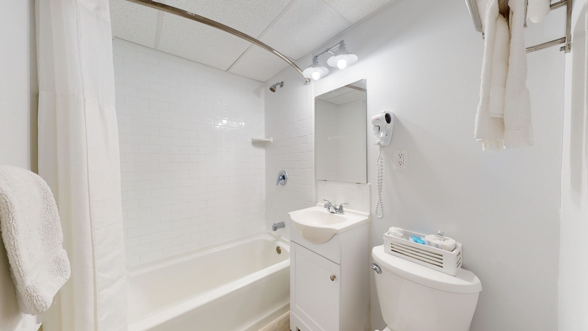 A bathroom with a sink , toilet , bathtub and mirror.